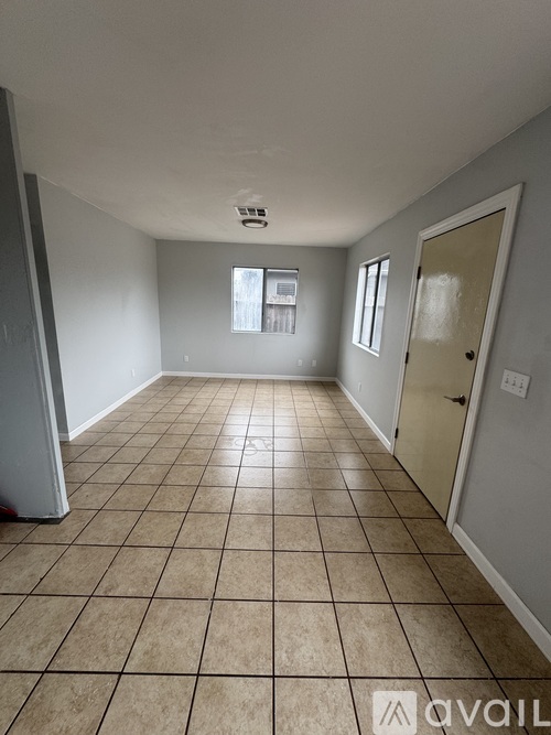 A room with tiled flooring and a door on the right.