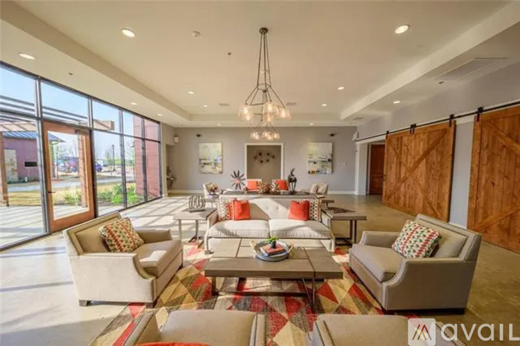 A spacious living room with a large rug and a coffee table.