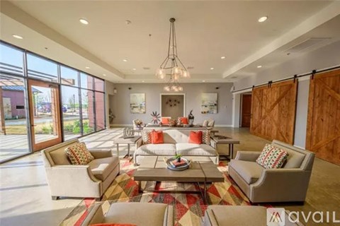 A spacious living room with a large rug and a coffee table.