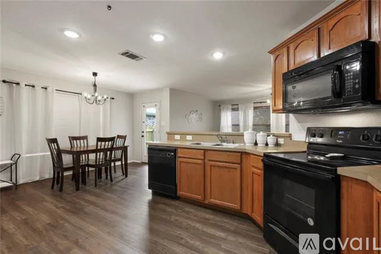A kitchen with black appliances and wooden cabinets.