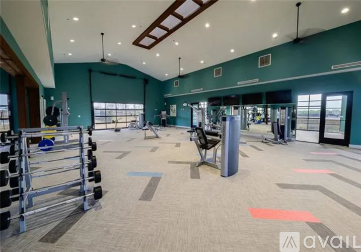 A gym with a variety of equipment including dumbbells, weight machines, and a bench press.