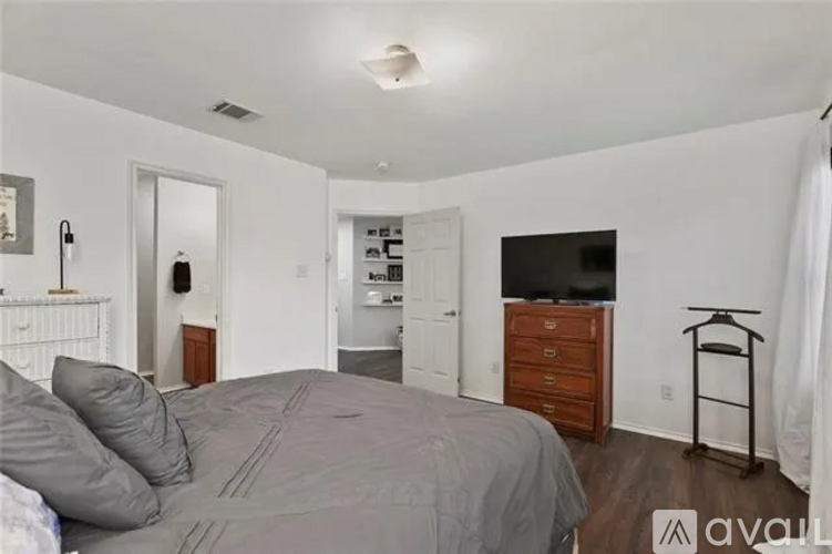 A bedroom with a bed, dresser, and mirror.