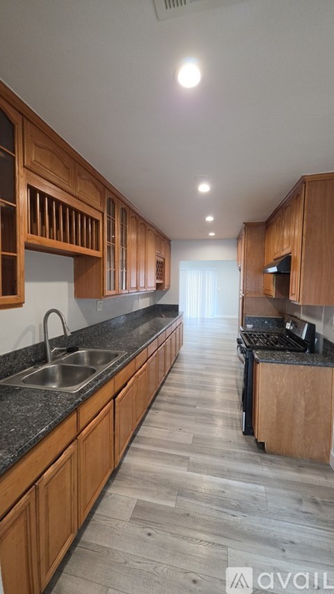 A kitchen with wooden cabinets and a black countertop.