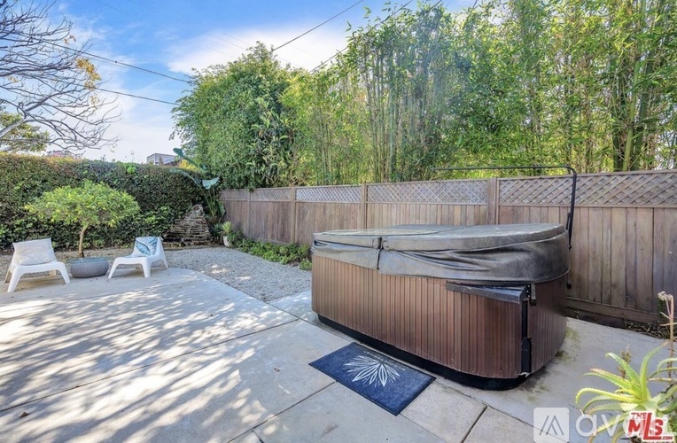 A backyard with a hot tub and patio furniture.