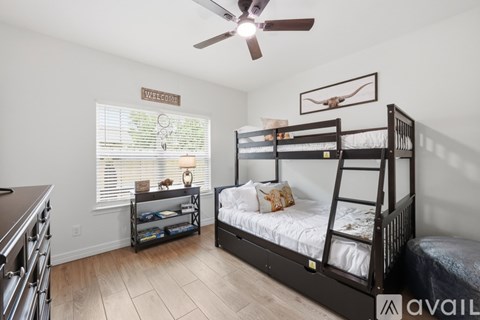 A bedroom with a bunk bed and a dresser.