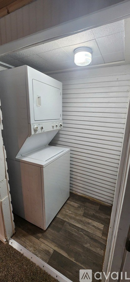 A white fridge in a room with a light on.