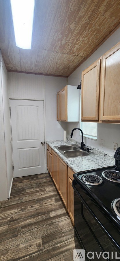 A kitchen with wooden cabinets and a black stove top oven.