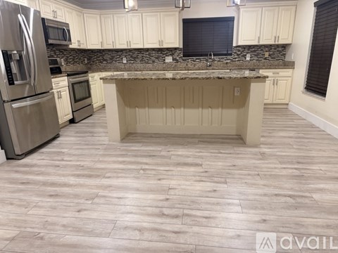 A kitchen with a granite countertop and stainless steel appliances.