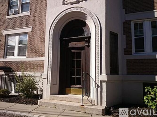 A brown door is in a white arch.