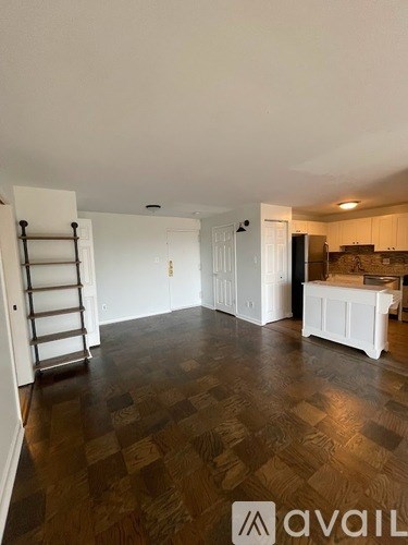 A room with wooden flooring and a ladder against the wall.