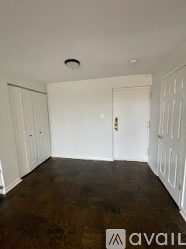 A room with a brown floor and white walls.
