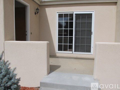 A small patio with a window and a door.