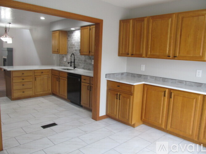 A kitchen with wooden cabinets and a marble countertop.