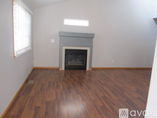 A room with a fireplace and wood flooring.