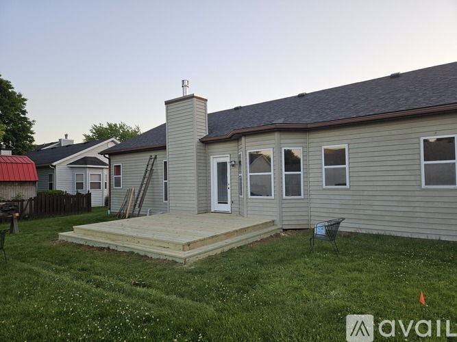 A house with a grey siding and a white door is available for purchase.