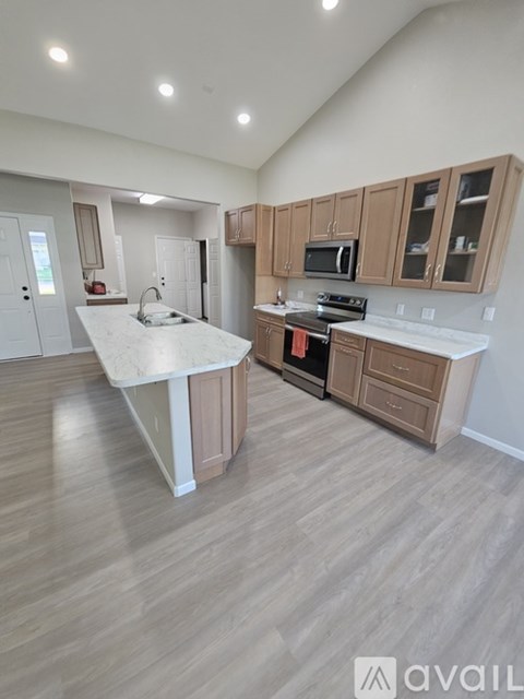 A kitchen with wooden cabinets and a white island.