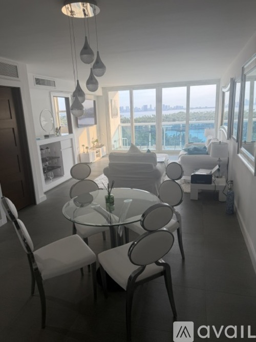 A modern dining room with a glass table and chairs.