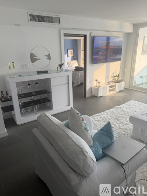 A modern living room with a grey couch and a white cabinet.