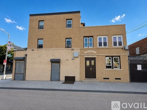 A beige building with a black door and windows.
