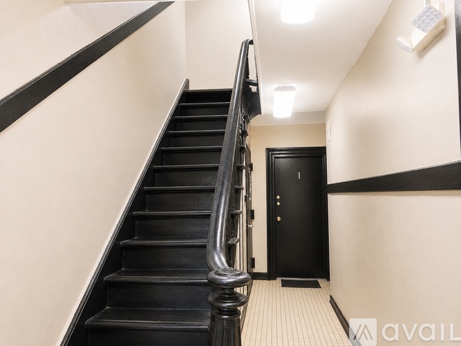 A black staircase with a silver handrail.
