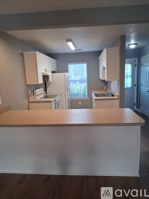 A kitchen with a white counter and cabinets.