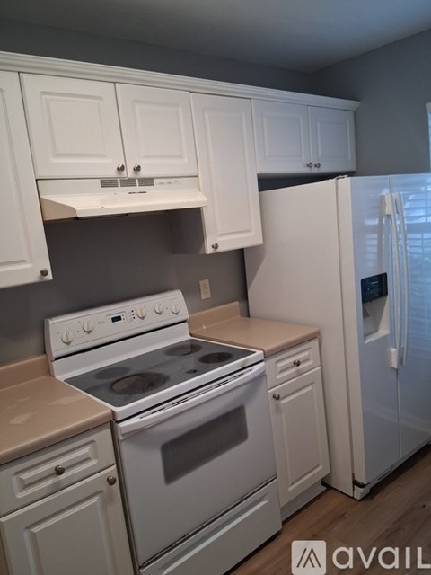 A kitchen with white appliances and cabinets.