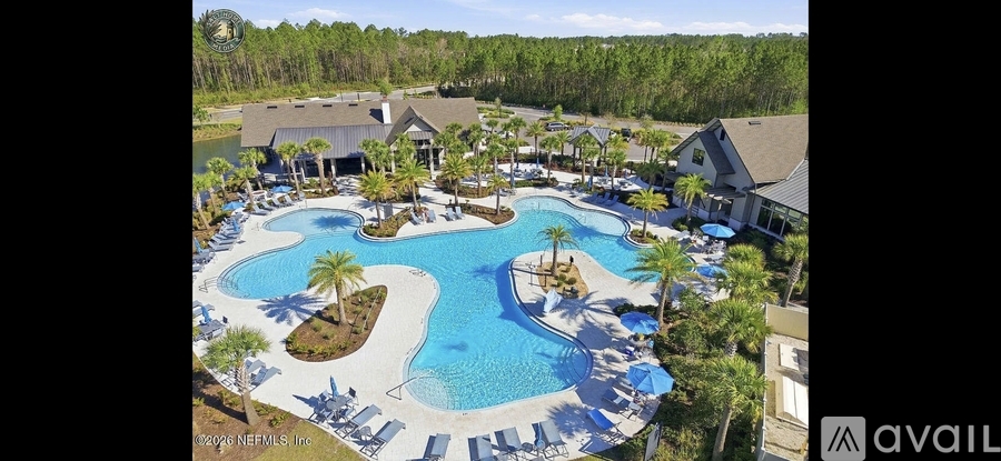A large outdoor swimming pool surrounded by lounge chairs and trees.