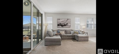 A living room with a grey sofa and a large painting on the wall.