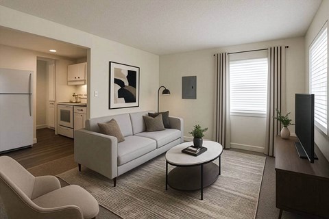 A living room with a grey couch and a white fridge.