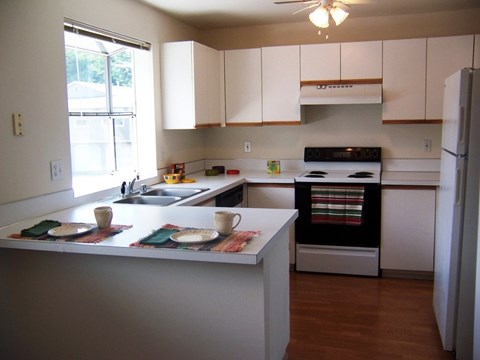 A kitchen with white cabinets and a black stove top oven.