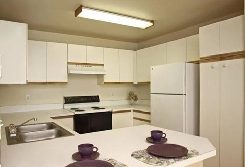 A kitchen with white cabinets and a black stove top oven.