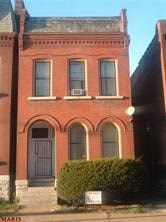 A red brick building with a black door and windows.