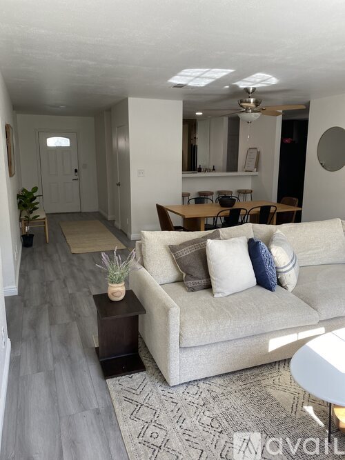 A living room with a couch, a coffee table, and a mirror.