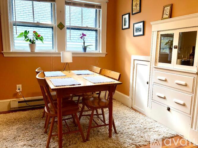 A dining room with a wooden table and chairs.