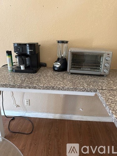 A kitchen counter with a coffee maker, blender, and toaster oven on it.