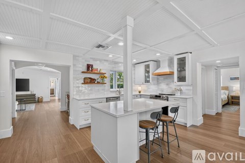 A modern kitchen with white cabinets and a large island.