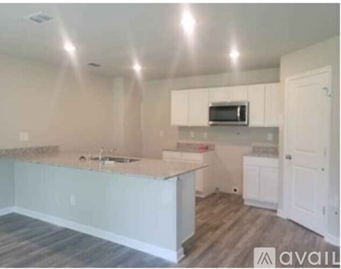 A kitchen with white cabinets and a countertop.