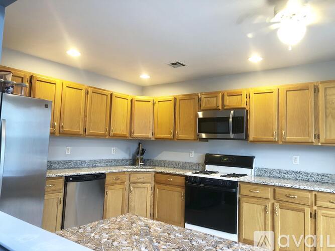 A kitchen with wooden cabinets and a black stove top oven.