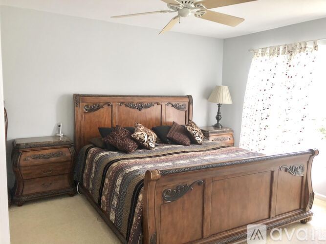 A bedroom with a large bed and a ceiling fan.