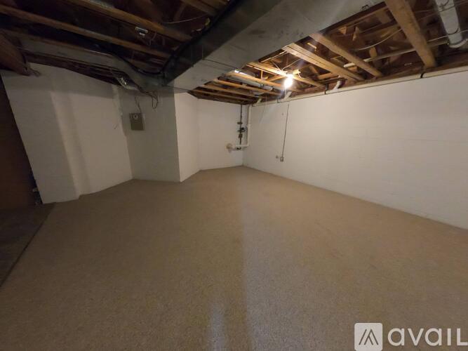 A spacious empty room with a wooden ceiling and beige carpet.