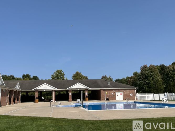 A swimming pool area with a building and a bird in the sky.
