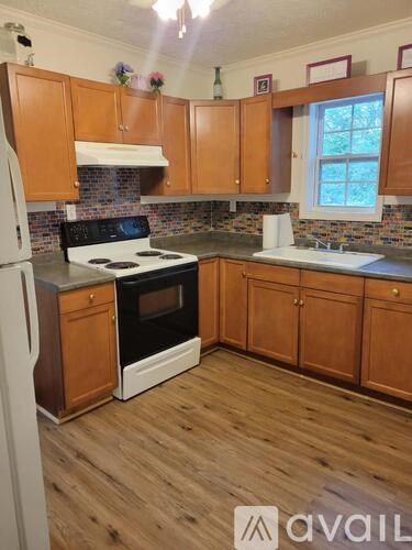 A kitchen with wooden cabinets and a white stove top oven.