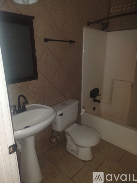 A bathroom with a toilet, sink, and shower.