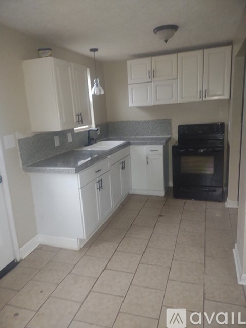 A kitchen with white cabinets and a black oven.