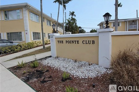 The Pointe Club is a residential building with a white sign in front.