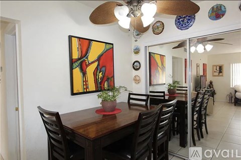 A dining room with a wooden table and chairs.