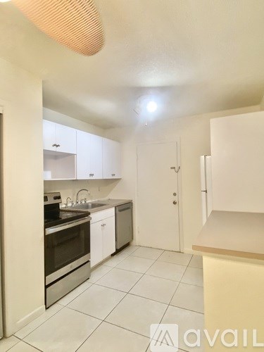 A kitchen with white cabinets and appliances.