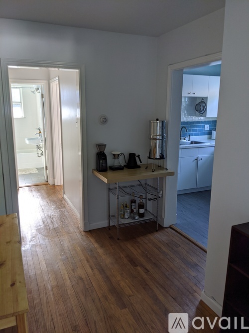 A kitchen with a wooden floor and white walls.