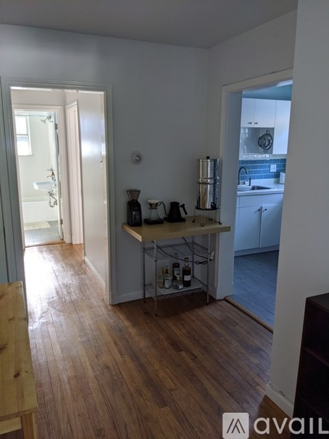 A kitchen with a wooden floor and white walls.