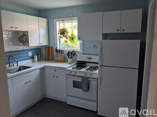 A kitchen with white appliances and cabinets.